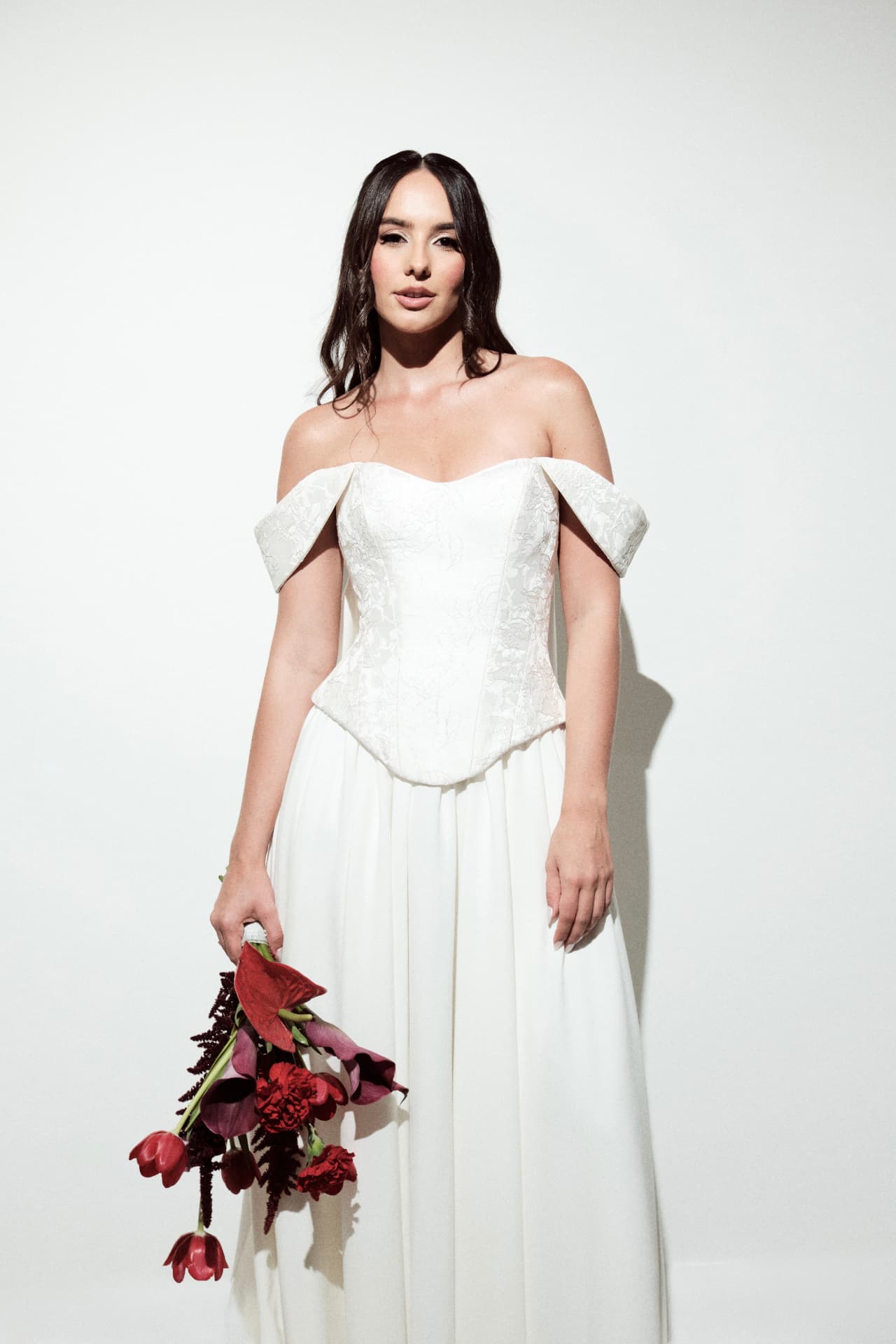 Noiva com buquê vermelho em fundo claro